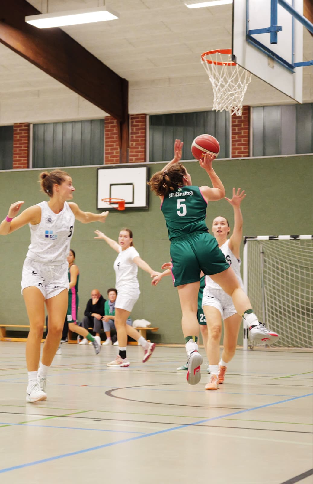 Spielerin Nr. 5 im grünen Trikot zieht zum Korb