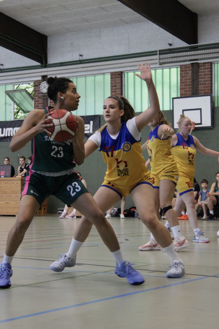 Spielerin Nr. 23 im grünen Trikot wird von einer Gegnerin im gelben Trikot gedeckt