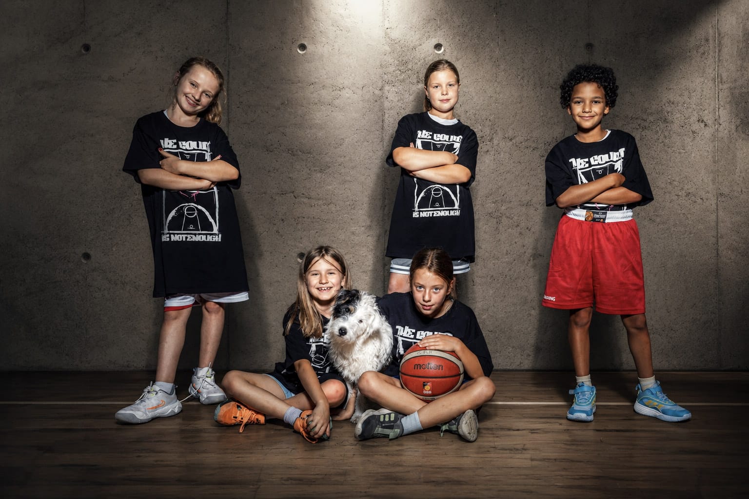 Fünf Kinder mit Hund und Bällen im Teamfoto