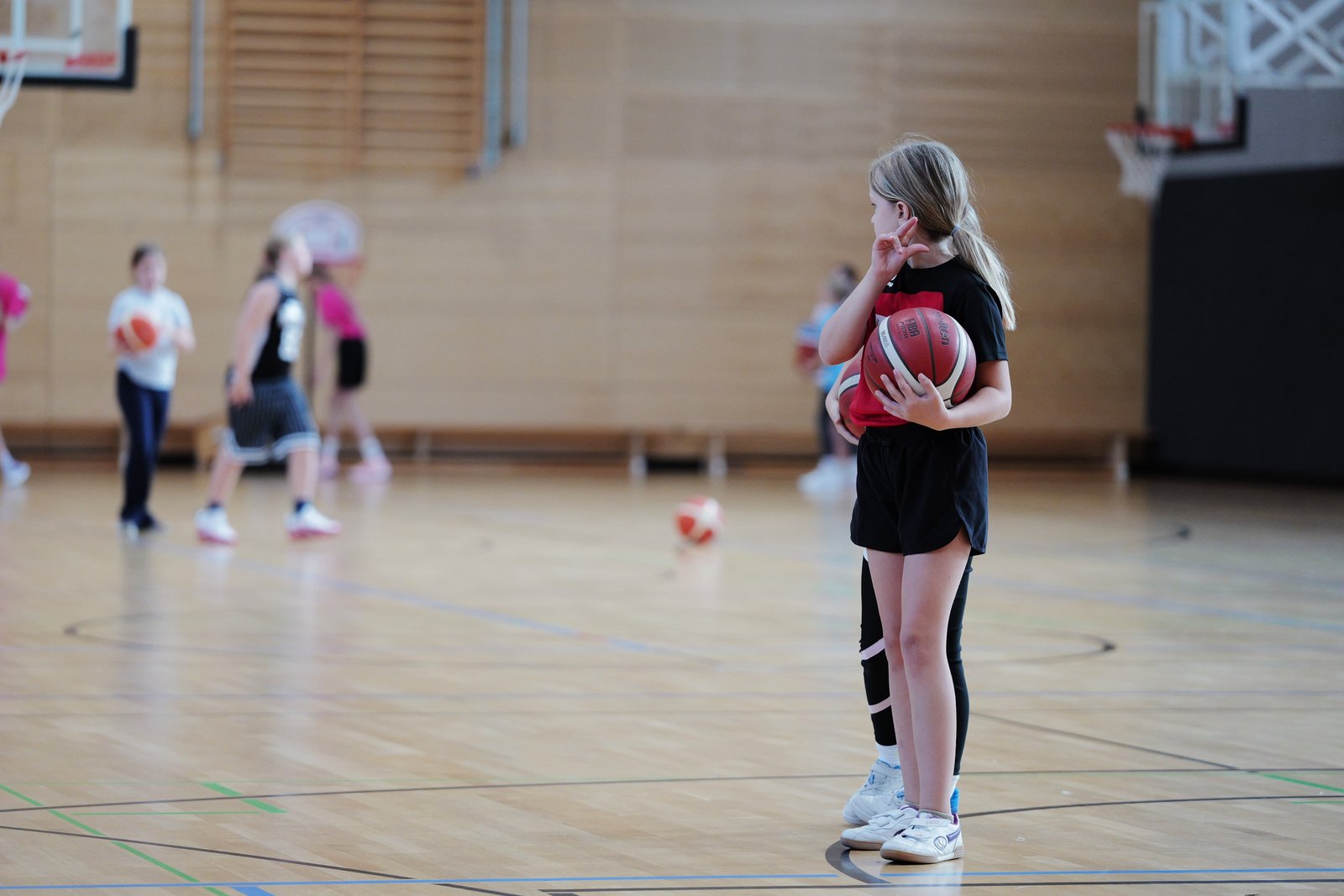 Ein Mädchen der U8w hält im Training einen Basketball im Arm